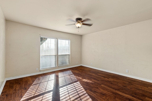 unfurnished room with ceiling fan and dark hardwood / wood-style flooring