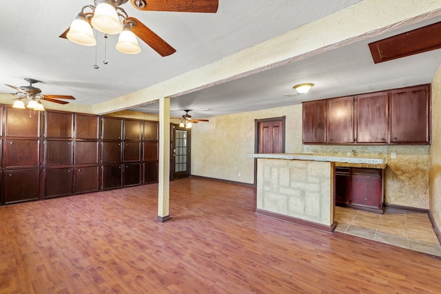 kitchen featuring kitchen peninsula, light hardwood / wood-style floors, and a textured ceiling