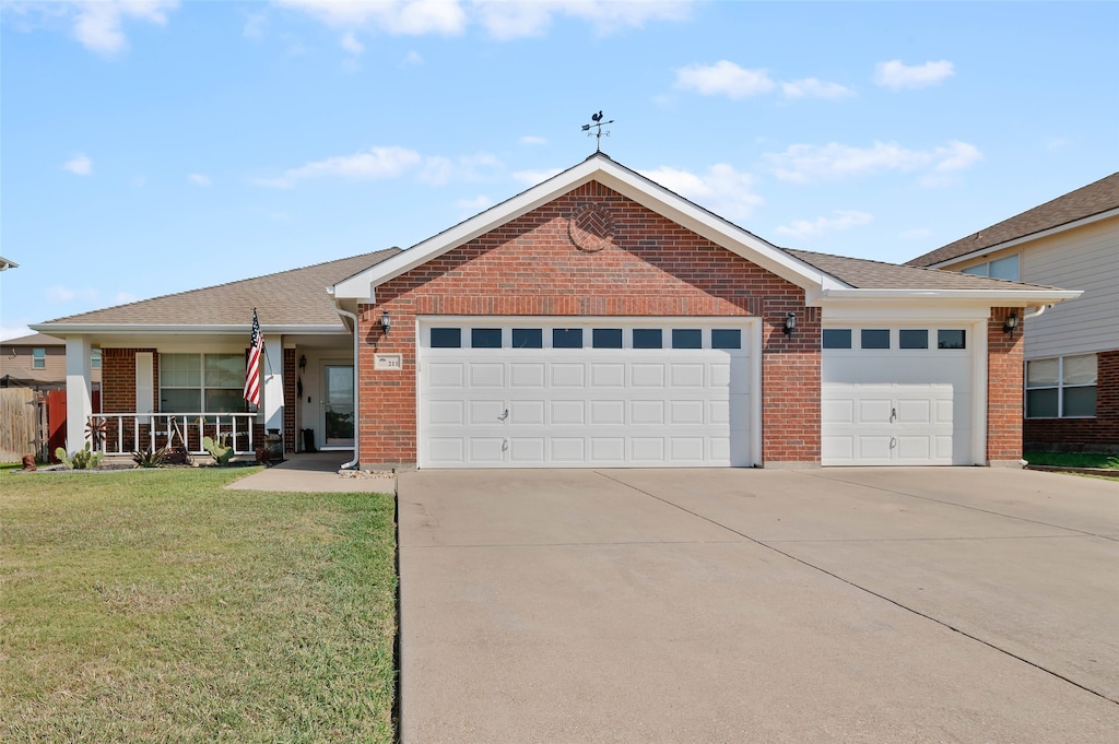 ranch-style house featuring a garage, a porch, and a front yard