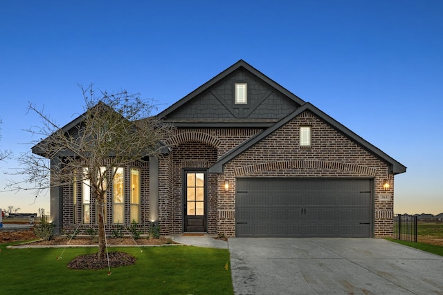 front of property with a garage and a lawn