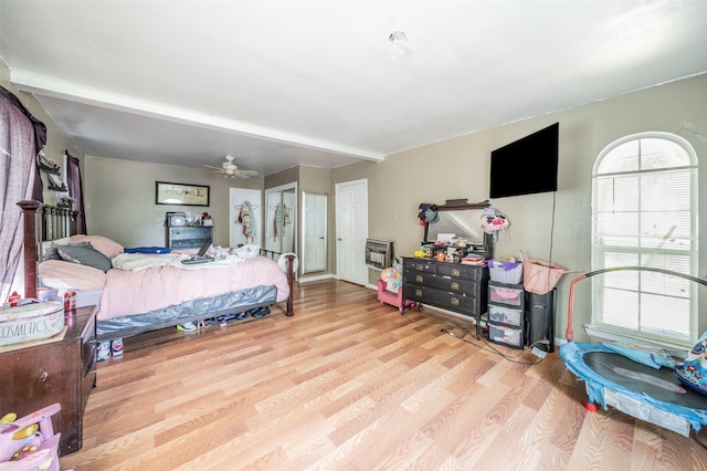 bedroom featuring heating unit and light hardwood / wood-style flooring