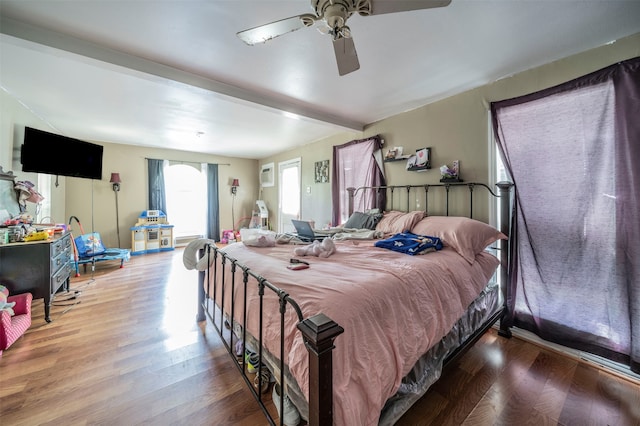 bedroom with ceiling fan, beamed ceiling, and wood-type flooring