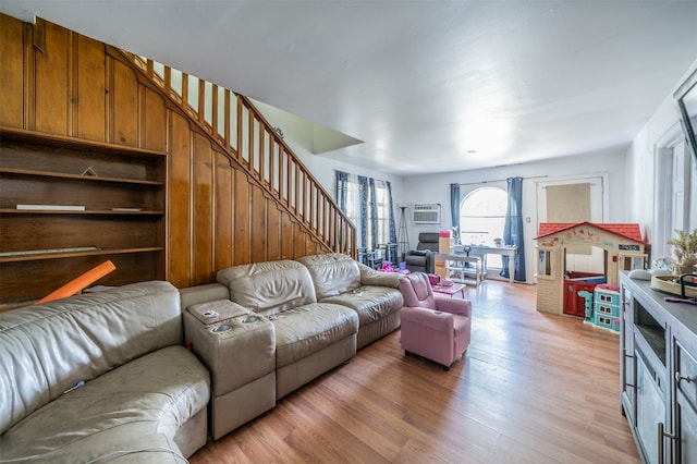 living room featuring light hardwood / wood-style floors and a wall unit AC