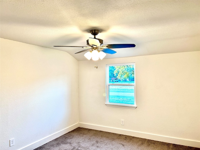 carpeted spare room featuring a textured ceiling, lofted ceiling, and ceiling fan