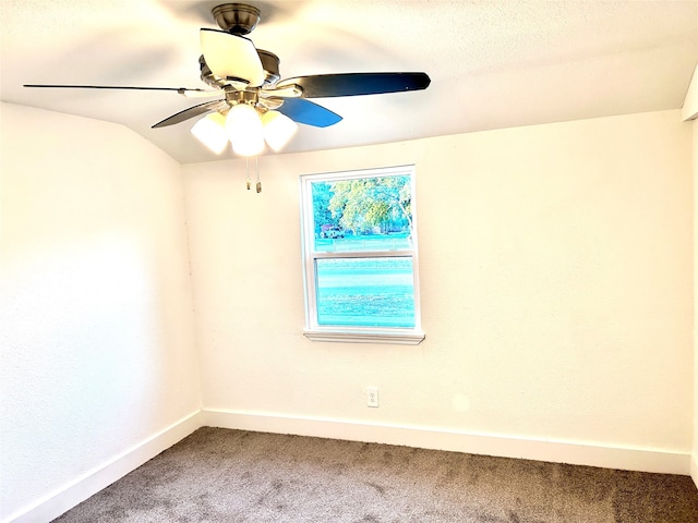 carpeted empty room featuring ceiling fan and vaulted ceiling