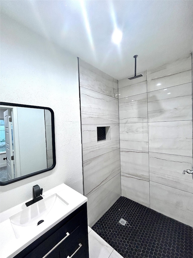 bathroom featuring vanity and tiled shower