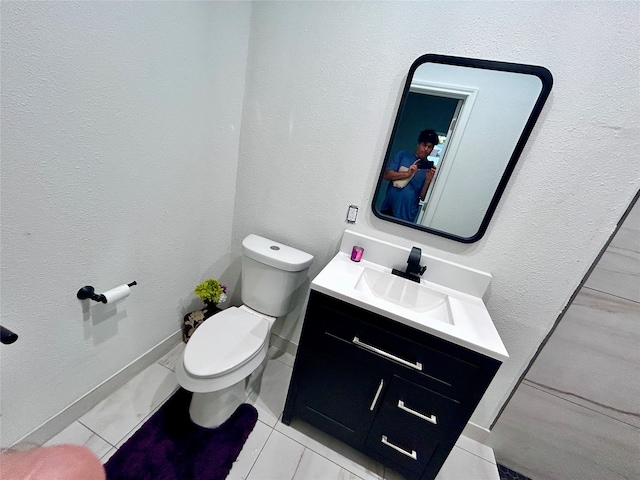 bathroom featuring tile patterned flooring, vanity, and toilet