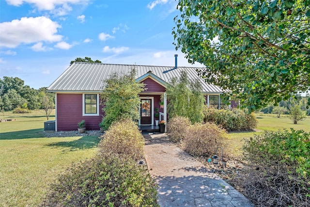 view of front facade with a front yard and metal roof