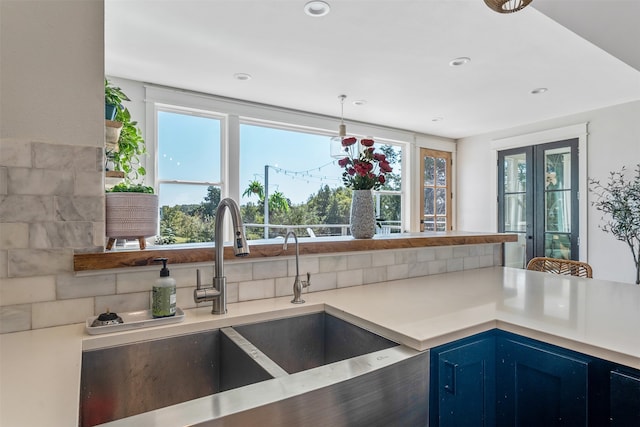 kitchen with a sink, blue cabinetry, recessed lighting, and light countertops