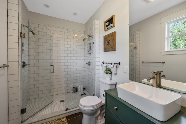 bathroom featuring tile patterned floors, an enclosed shower, vanity, and toilet