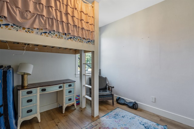 bedroom with baseboards and wood finished floors