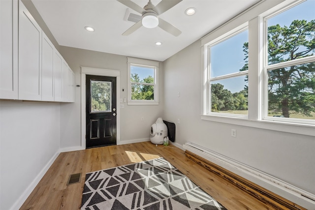 entrance foyer with a healthy amount of sunlight, ceiling fan, light hardwood / wood-style floors, and a baseboard radiator