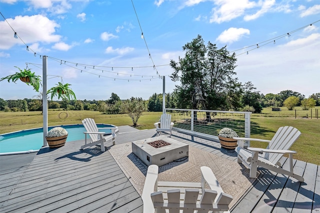 deck with a lawn, an outdoor pool, and a fire pit