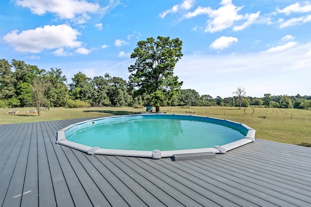 view of swimming pool with a lawn and a wooden deck