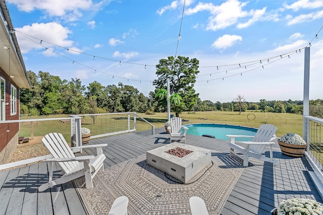 wooden terrace featuring a fire pit and a lawn