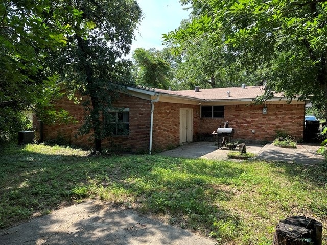 rear view of property featuring a patio area and a yard