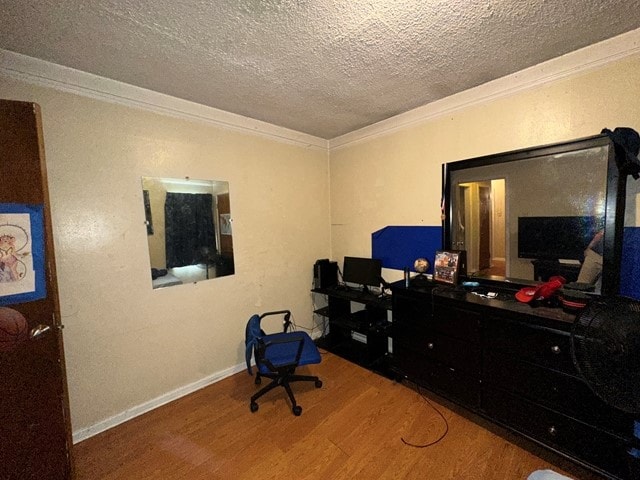 home office featuring crown molding, wood-type flooring, and a textured ceiling