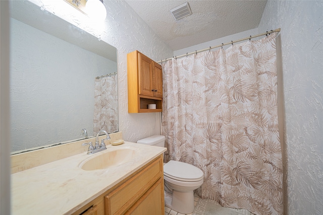 bathroom featuring vanity, tile patterned flooring, toilet, and a textured ceiling