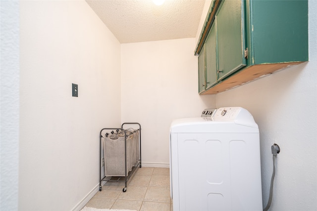 laundry area with washer and clothes dryer, cabinets, light tile patterned floors, and a textured ceiling