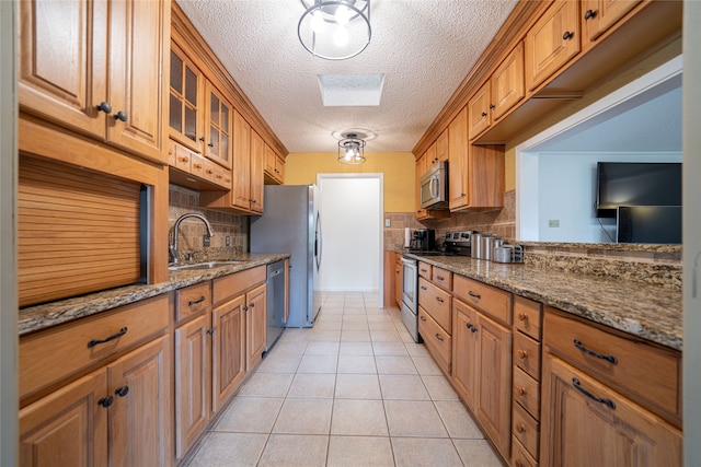 kitchen featuring stainless steel appliances, decorative backsplash, sink, and stone countertops