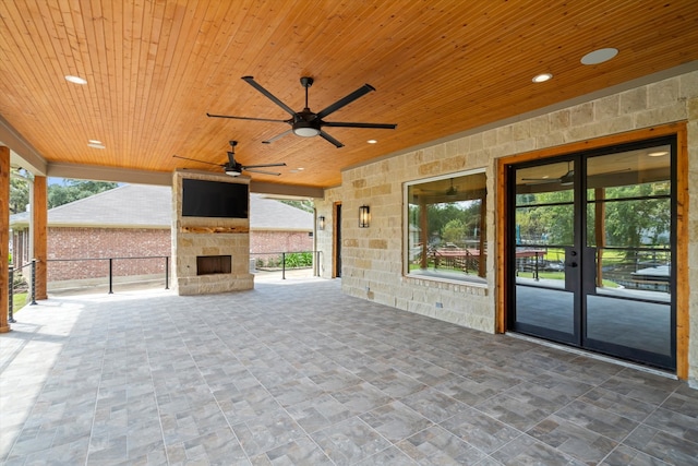 view of patio / terrace with french doors, an outdoor stone fireplace, and ceiling fan