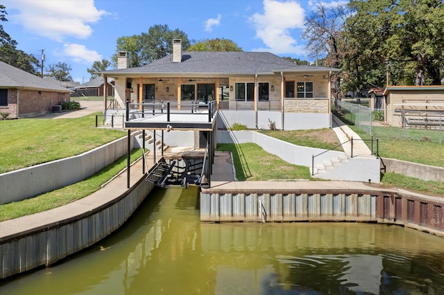 rear view of property with a yard and a water view