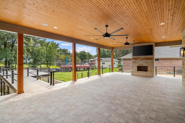 view of patio / terrace with ceiling fan and an outdoor stone fireplace