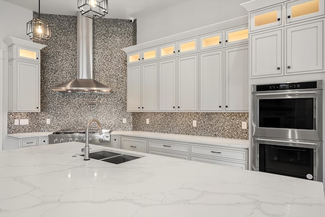 kitchen with sink, appliances with stainless steel finishes, pendant lighting, and white cabinetry