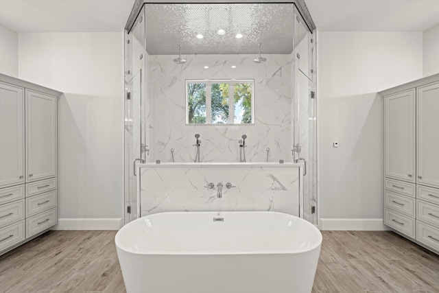 bathroom with independent shower and bath and hardwood / wood-style floors