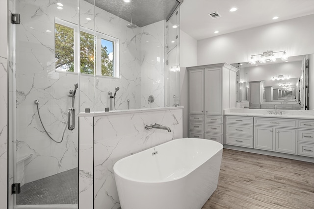 bathroom with vanity, shower with separate bathtub, and wood-type flooring