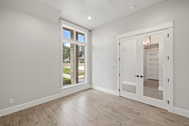 unfurnished bedroom with light hardwood / wood-style flooring, french doors, and a closet