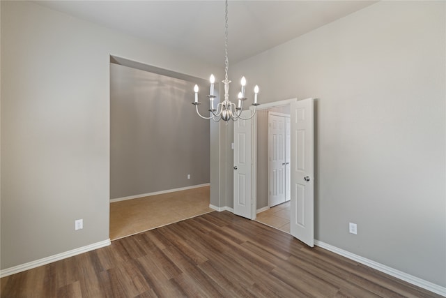 unfurnished dining area with a chandelier and wood-type flooring