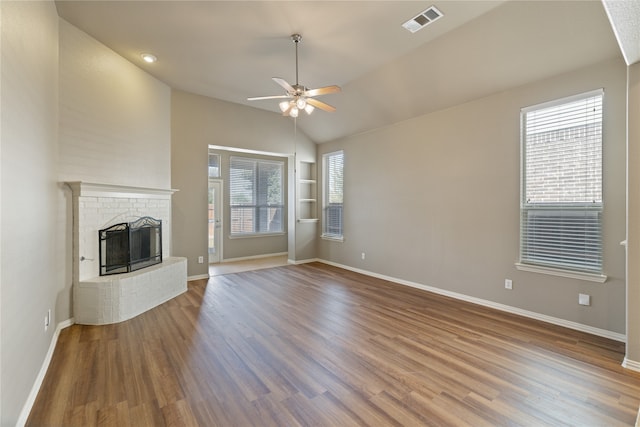 unfurnished living room with wood-type flooring, a fireplace, plenty of natural light, and ceiling fan