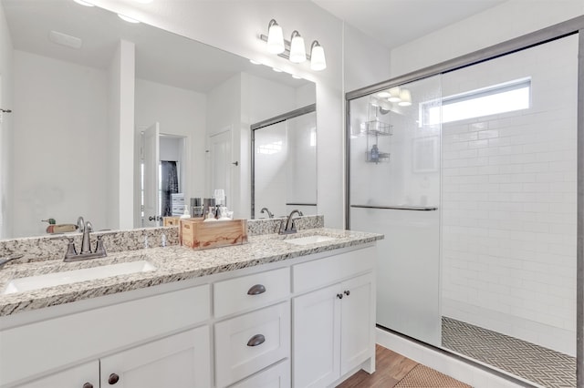 bathroom with vanity, an enclosed shower, and hardwood / wood-style flooring