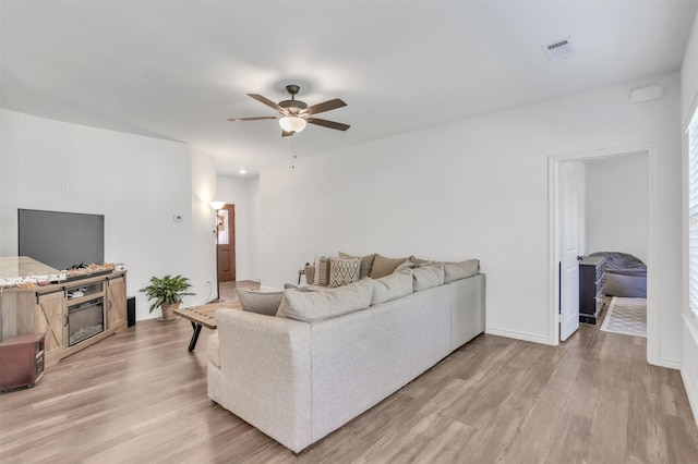 living room with light hardwood / wood-style flooring and ceiling fan