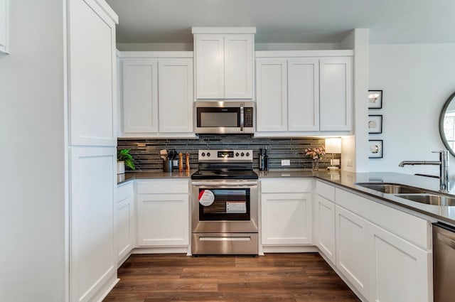 kitchen with decorative backsplash, stainless steel appliances, sink, dark hardwood / wood-style flooring, and white cabinetry