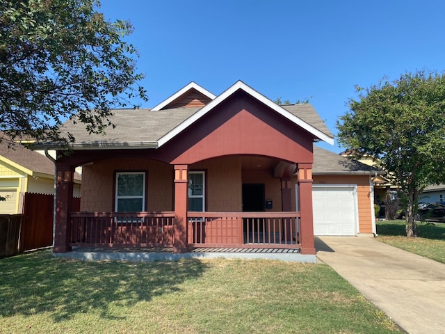 view of front of home featuring a front yard, a garage, and covered porch