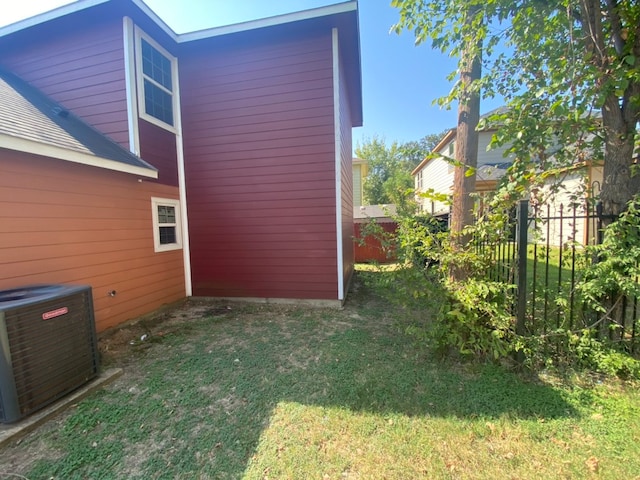 view of home's exterior with a lawn and central AC