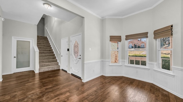 foyer with hardwood / wood-style flooring, stairway, crown molding, and a wainscoted wall