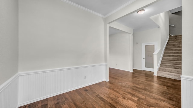 unfurnished room featuring stairway, wood finished floors, a wainscoted wall, and crown molding