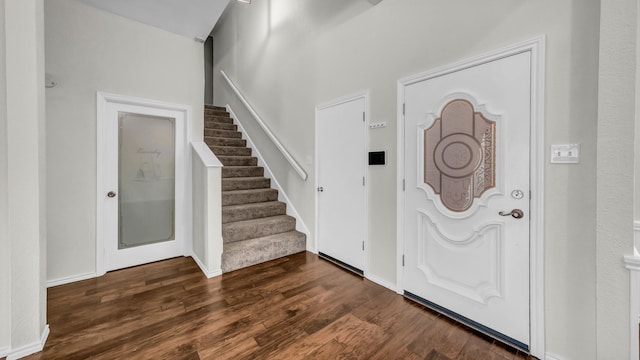 entrance foyer with stairs, baseboards, and dark wood-style flooring