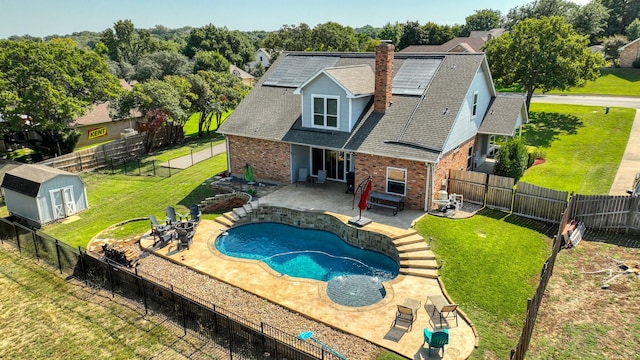 back of property with brick siding, a storage shed, an outdoor structure, a fenced backyard, and a patio