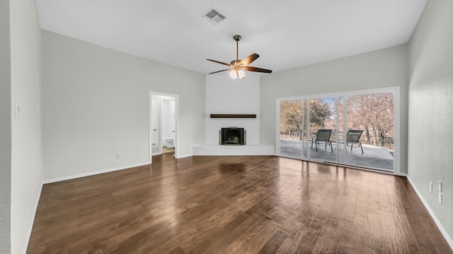 unfurnished living room with wood finished floors, visible vents, baseboards, a fireplace, and ceiling fan