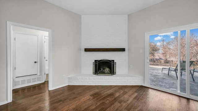 unfurnished living room featuring a fireplace, baseboards, and hardwood / wood-style floors