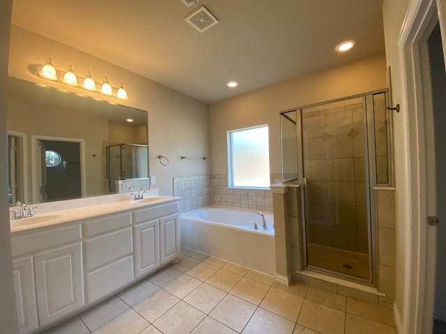 bathroom featuring vanity, shower with separate bathtub, and tile patterned floors