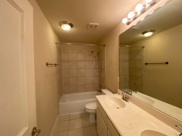 full bathroom featuring tiled shower / bath, tile patterned floors, vanity, and toilet