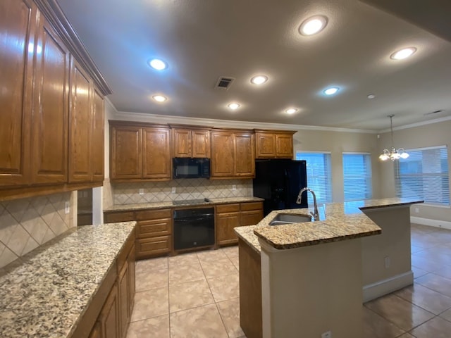 kitchen with a kitchen island with sink, sink, tasteful backsplash, and black appliances