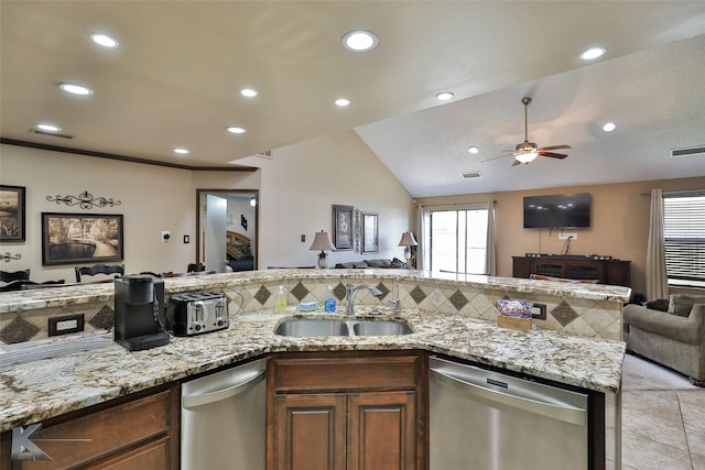 kitchen featuring light stone counters, ceiling fan, sink, dishwasher, and vaulted ceiling