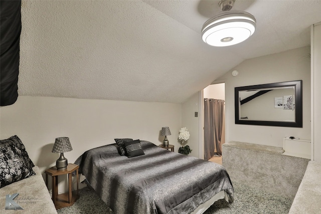 bedroom with vaulted ceiling, carpet, and a textured ceiling