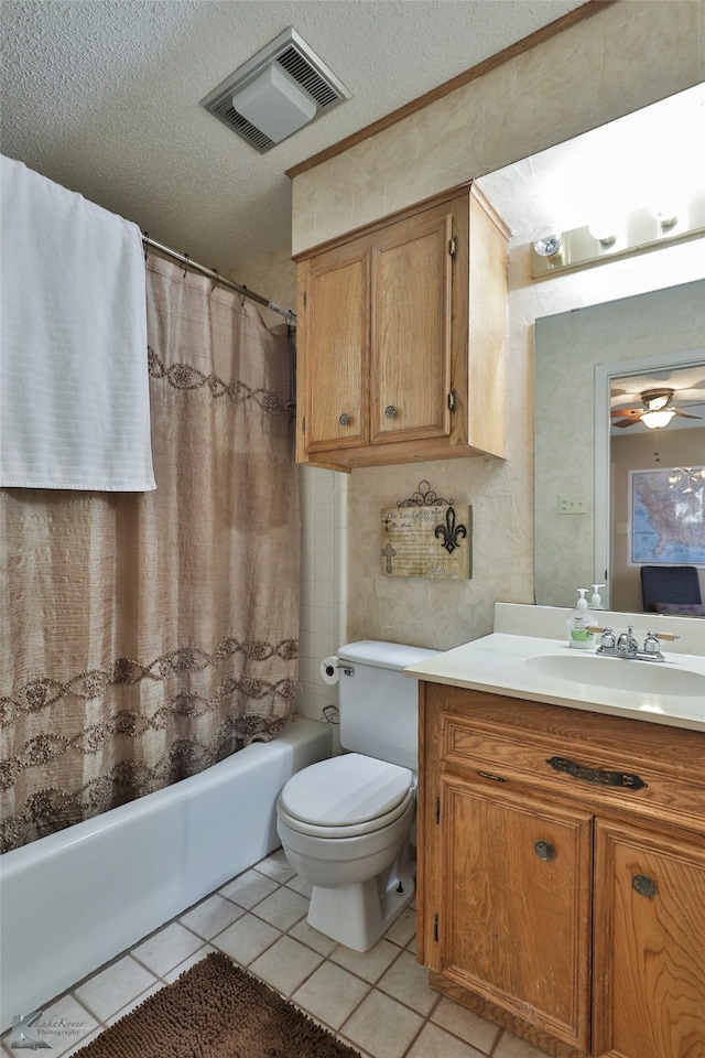 full bathroom featuring vanity, shower / bath combo with shower curtain, tile patterned floors, toilet, and a textured ceiling